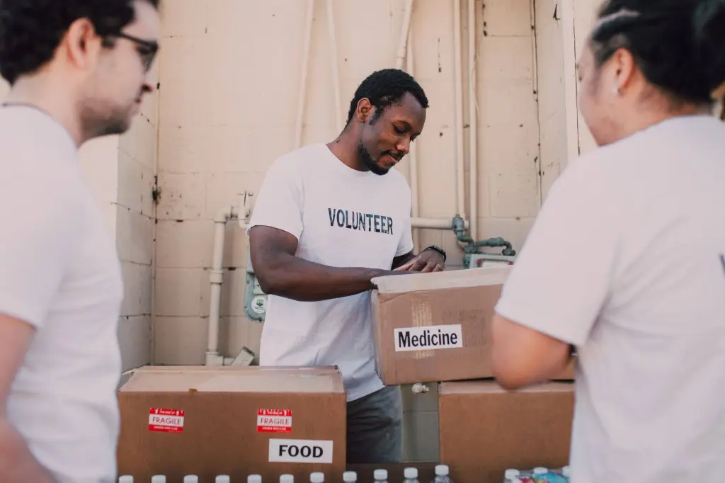 Volunteers packing food and medicine boxes for donation. Community service and support efforts.