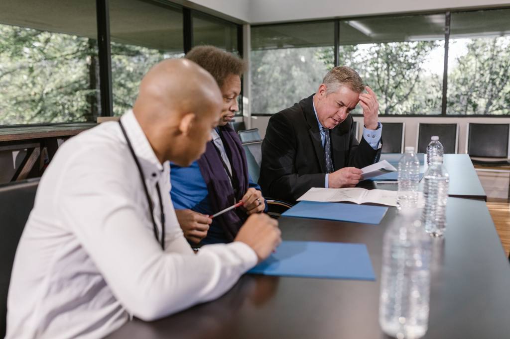 Group of diverse colleagues in a business meeting reviewing documents indoors.